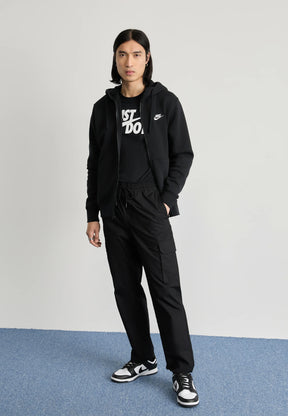 Felpa nera con zip, t-shirt grafica nera, pantaloni cargo e scarpe da ginnastica bianche e nere. Tessuto morbido, vestibilità comoda e dettagli in argento.