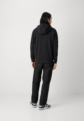 Felpa nera con cappuccio, polsini e orlo a costine, abbinata a pantaloni cargo neri con tasche laterali e sneakers bianche con dettagli neri.