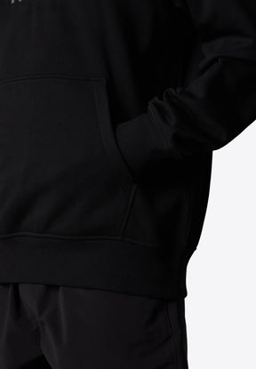 Felpa nera con tasca a marsupio, polsini e orlo a costine, e una texture morbida. Il design è minimalista e privo di motivi.